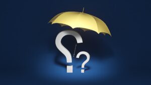 Two adults sit at a kitchen table reviewing insurance documents together.