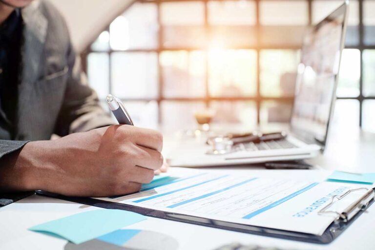Family reviewing life insurance documents and beneficiary forms at a kitchen table.